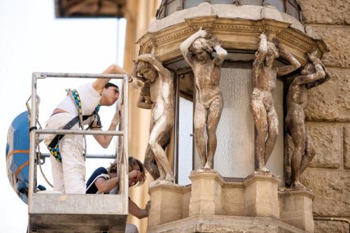 Two female workers in a boom lift wearing saftey harnesses