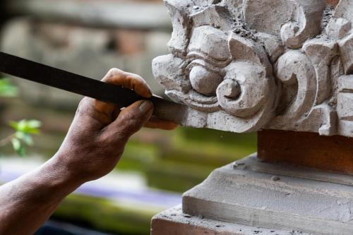 Stone carving master making statue of a Balinese deity. Bali, Ubud.